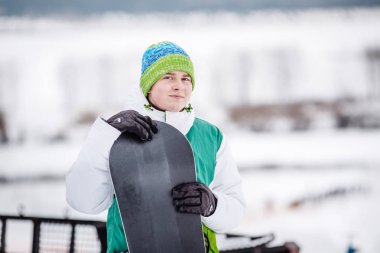 Genç adam ayaktaydï snowboard ile kar üzerinde