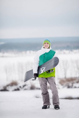 Genç adam ayaktaydï snowboard ile kar üzerinde