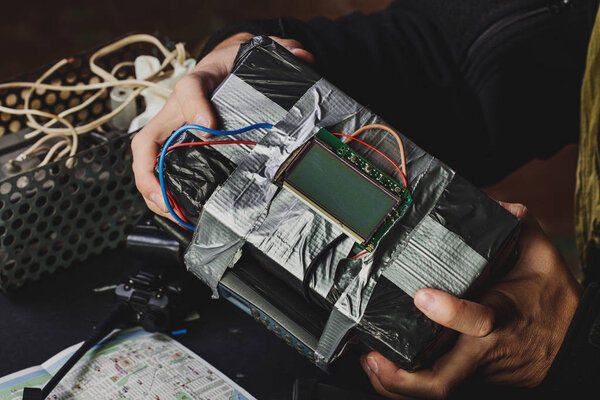 человек делает бомбу замедленного действия. терроризм и опасная концепция
.