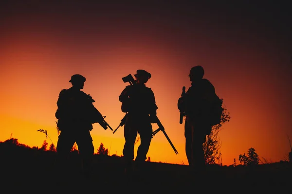 Silueta de soldados militares con armas por la noche —  Fotos de Stock