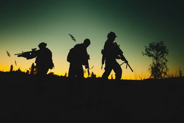 Silhuett av militære soldater med våpen om natten – stockfoto