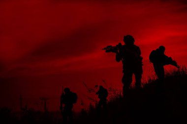 Silhouette of military soldiers with weapons at night clipart