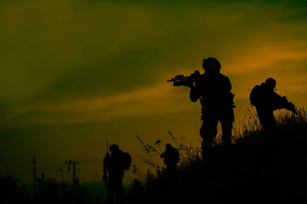 Silhouette of military soldiers with weapons at night — Stock Photo, Image