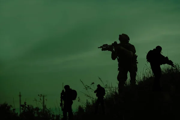 Silhuett av militære soldater med våpen om natten – stockfoto