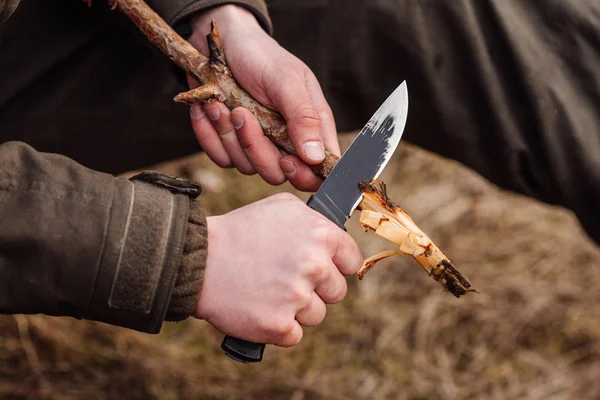 Охотник на крупным планом с ножом разрезал деревянную палку — стоковое фото