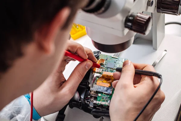 Le mani ravvicinate di un operatore di servizi che ripara la fotocamera digitale . — Foto Stock