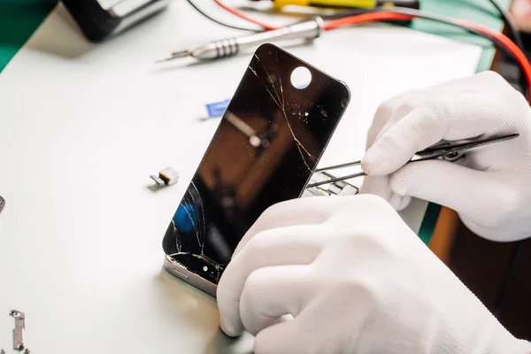 Nahaufnahme eines Servicemitarbeiters, der moderne Smartphones repariert. — Stockfoto
