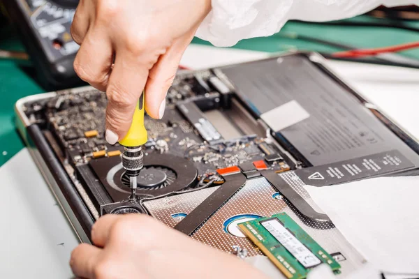 Woman repairing laptop computer in service center. — Stock Photo, Image