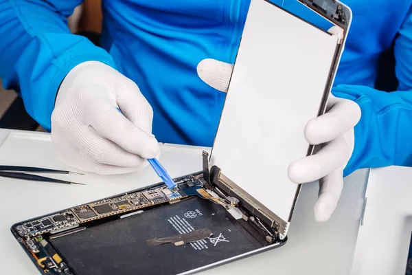 Закрыть руки обслуживающего работника, ремонтирующего современные планшетные компьютеры — стоковое фото