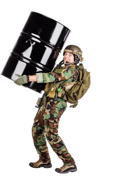Uomo con il fucile che trasporta un barile di petrolio — Foto Stock
