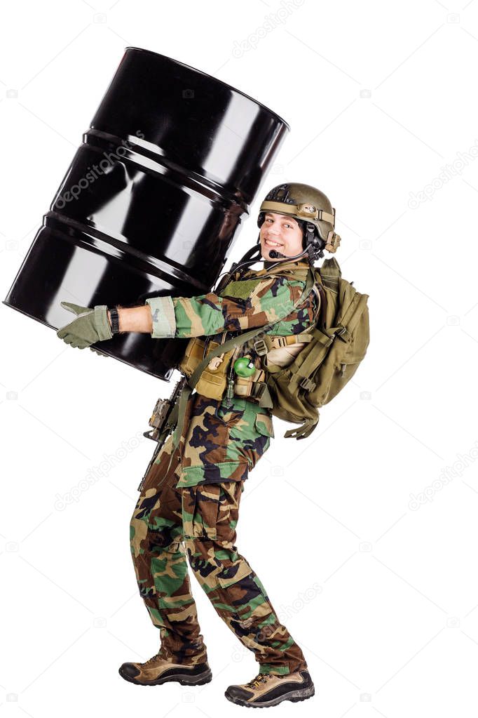man with his rifle carrying an oil barrel