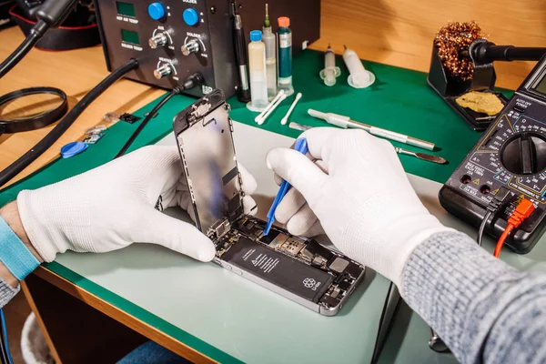 Ręce pracownika usługi naprawy nowoczesnych smarphone z bliska. — Zdjęcie stockowe