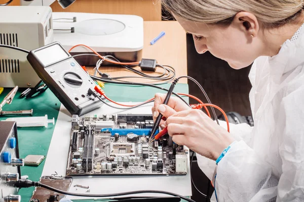 woman repairing computer hardware in service center