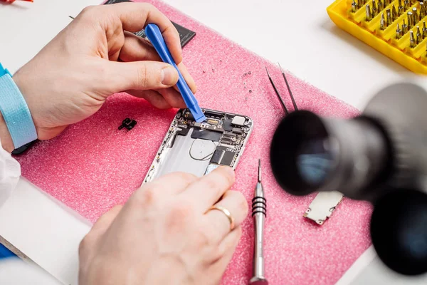 Close-up van de handen van een werknemer van de dienst moderne smarphone herstellen. — Stockfoto