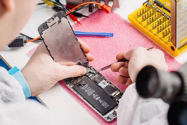 Close-up van de handen van een werknemer van de dienst moderne smarphone herstellen. — Stockfoto