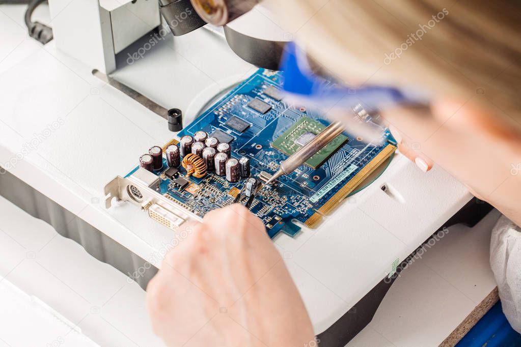 woman repairing computer hardware in service center