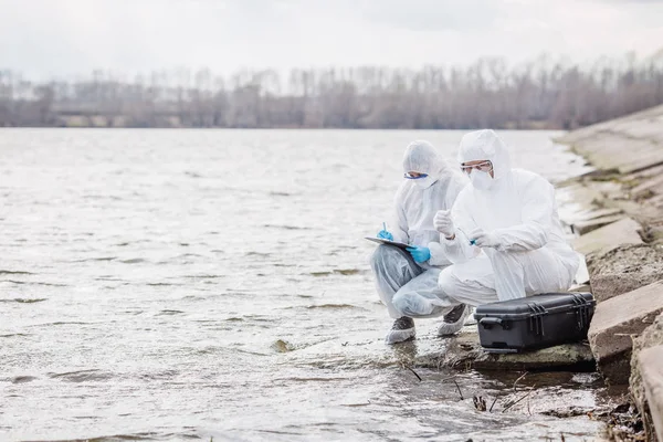 Científicos o biólogos con uniformes protectores trabajando juntos —  Fotos de Stock