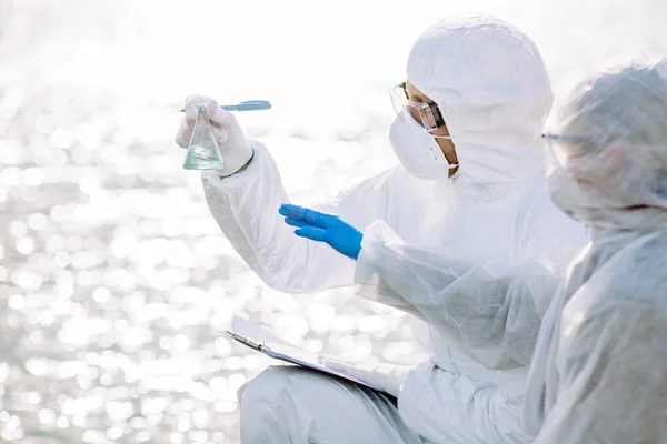 Científicos o biólogos trabajando juntos en el análisis del agua . — Foto de Stock