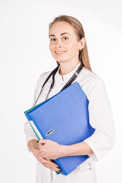 Médico sonriendo, sosteniendo la carpeta y mirando a la cámara . — Foto de Stock