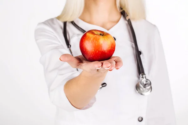 Ärztin hält roten Apfel in der Hand — Stockfoto