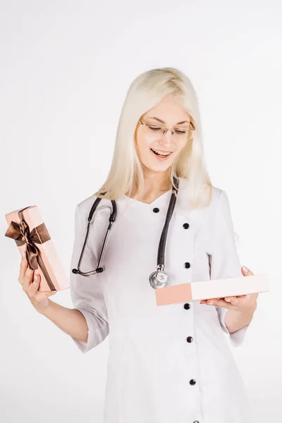 Doctora con estetoscopio sosteniendo caja de regalo abierta —  Fotos de Stock