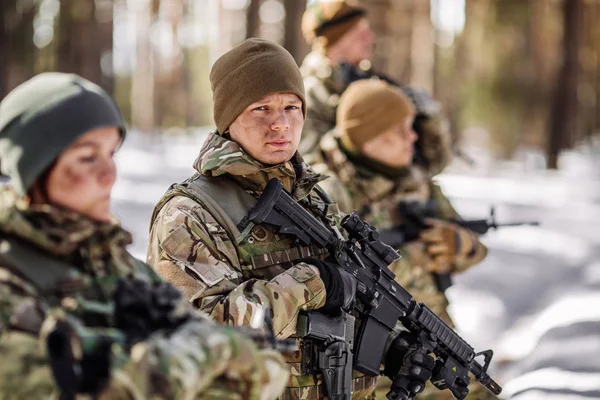 Team of  airborne infantry men with weapons standing at the sunset, side view. Military, war, conflict, soldiers concept