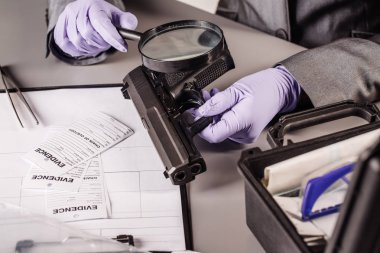 Dedektif bir kanıtlara bakarak bir büyüteç aracılığıyla