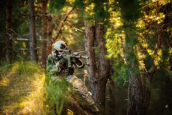 Portrait of young soldier  with rifle against a sunset backgroun — Stock Photo, Image