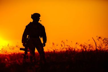 military soldier with weapons at sunset. shot, holding gun, colo clipart