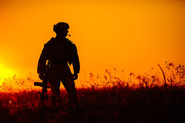 military soldier with weapons at sunset. shot, holding gun, colo