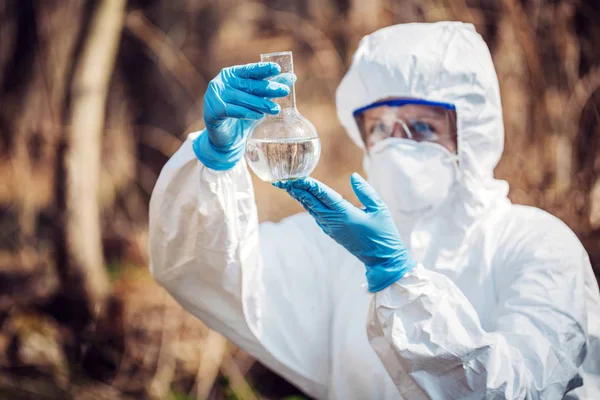 森でフラスコの液体の内容を調べて 女性科学者のクローズ アップ 生態と環境汚染の概念 — ストック写真