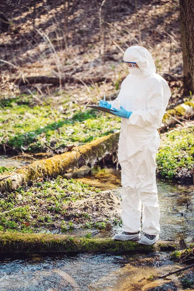 Cientista fêmea examinando o conteúdo líquido de um tubo de ensaio i — Fotografia de Stock