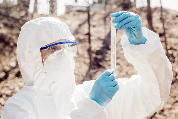 Cientista fêmea examinando o conteúdo líquido de um tubo de ensaio i — Fotografia de Stock