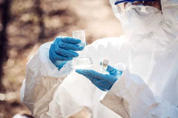 Cientista fêmea examinando o conteúdo líquido de um tubo de ensaio i — Fotografia de Stock