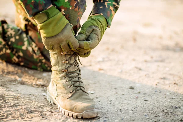 Bottes et mains attachant des bootlaces dans le désert — Photo