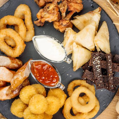 Fast food aperatifler bira ile kompozisyon. Sağlıksız abur cubur