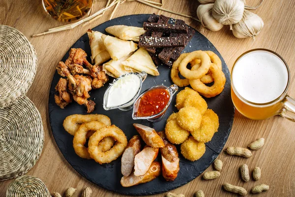 Fast food aperatifler bira ile kompozisyon. Sağlıksız abur cubur