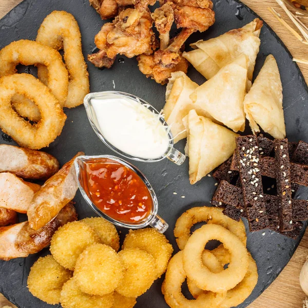 Fast food aperatifler bira ile kompozisyon. Sağlıksız abur cubur