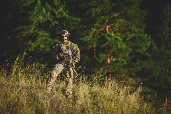 солдат спецназа в действии, указывающий на цель и дающий
