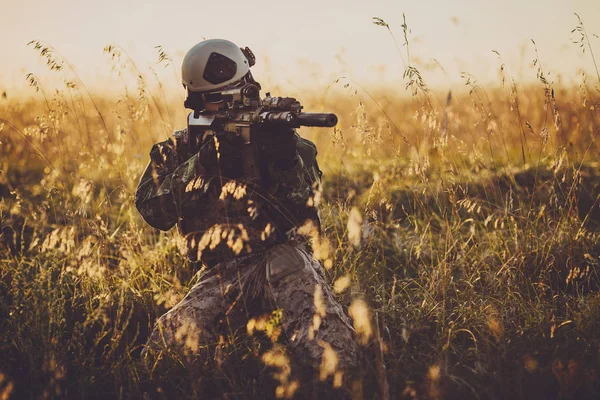 Retrato de cara de soldado jovem com camuflagem contra um pôr do sol — Fotografia de Stock