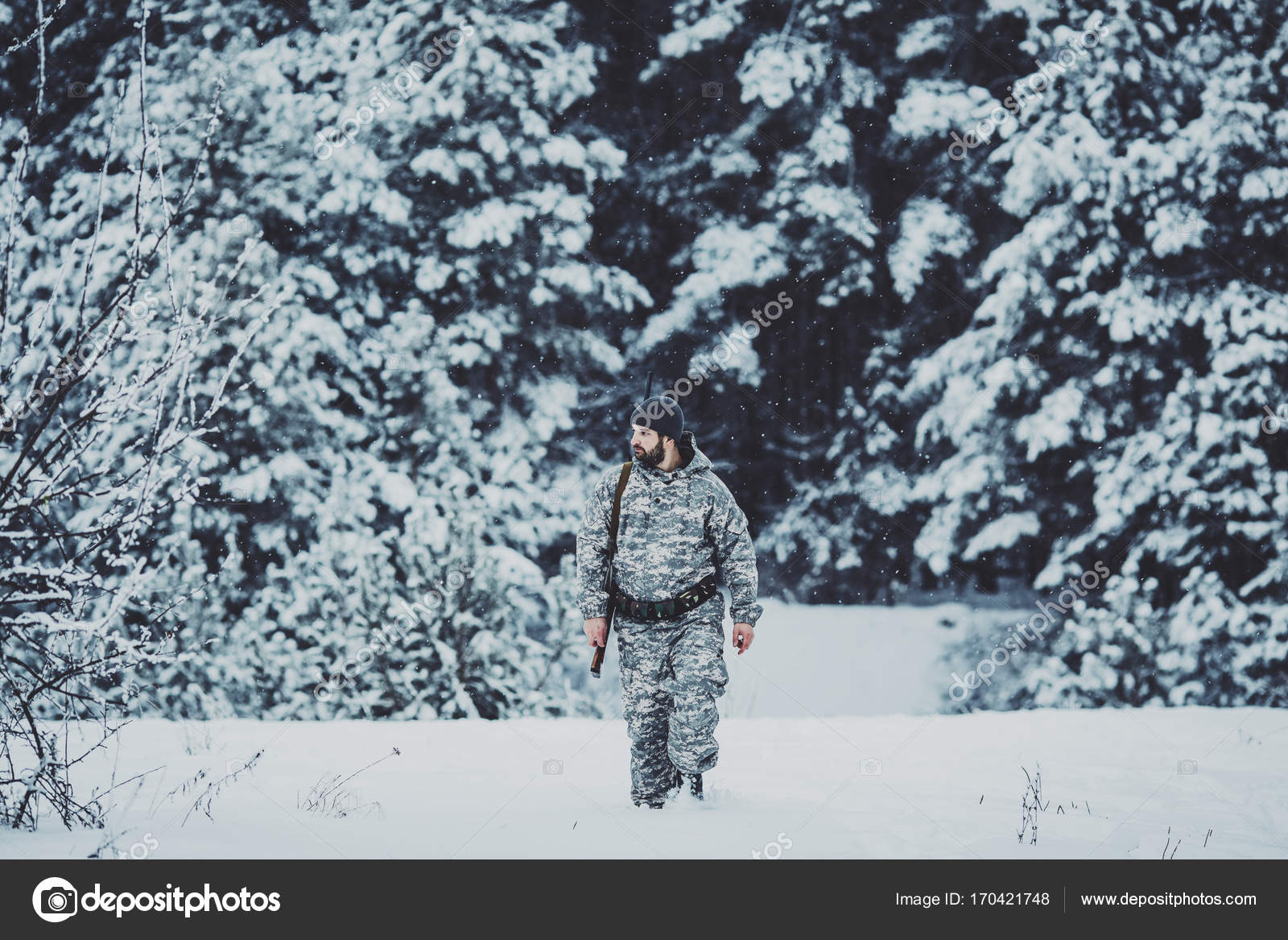 Male hunter in camouflage looking for his target or prey .Winter Stock