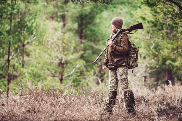 Kvinnliga jägare i kamouflage kläder redo att jaga, hålla pistolen en — Stockfoto