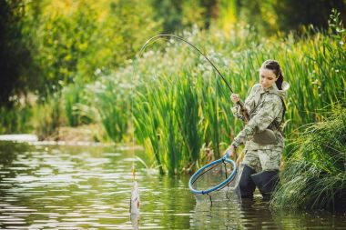 güzel kadın balıklar Nehri üzerinde. İplik donanımları, olta balıkçılığı, f
