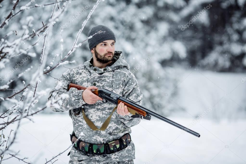 Male hunter in camouflage looking for his target or prey .Winter