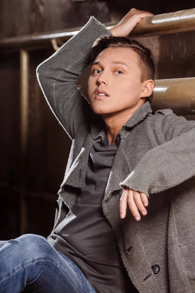 Duvara yakın oturan adam. Şık bir tarzda bir adam.