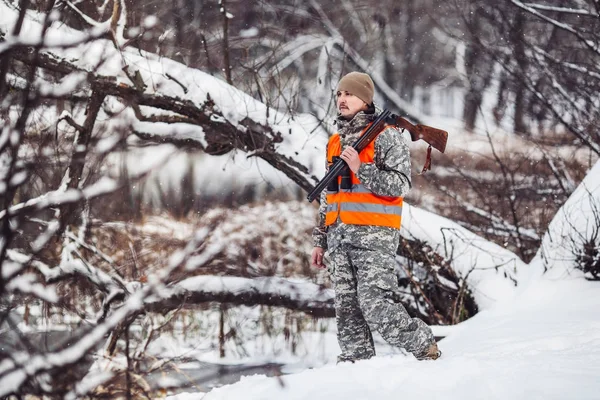 Kamuflaj, erkek avcısı silahlı bir tüfekle bir sno ayakta — Stok fotoğraf