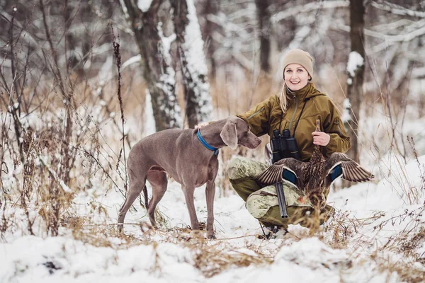 Kvinnliga jägare i kamouflage, beväpnad med ett gevär, stående i en s — Stockfoto