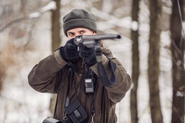 Kamuflaj, erkek avcısı silahlı bir tüfekle bir sno ayakta