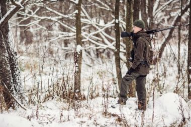 Kamuflaj, erkek avcısı silahlı bir tüfekle bir sno ayakta