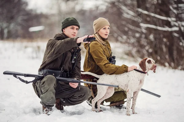 Two hunters with rifles in a snowy winter forest. — Stock Photo, Image